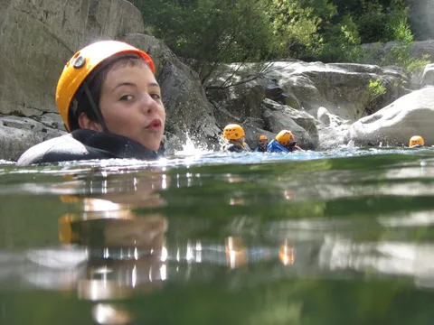 Nage dans une vasque en canyoning, casque et combinaison néoprène