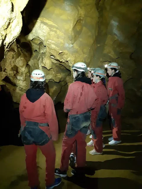 Groupe en sortie spéléologie, combinaisons et éclairages sous terre