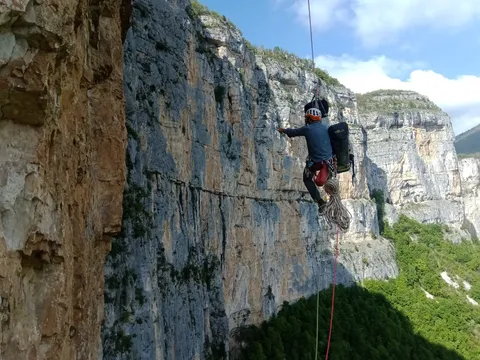 Parcours encordé au bord d’une falaise, vue sur la vallée